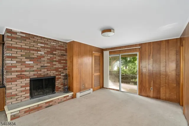 an empty room with windows and fireplace