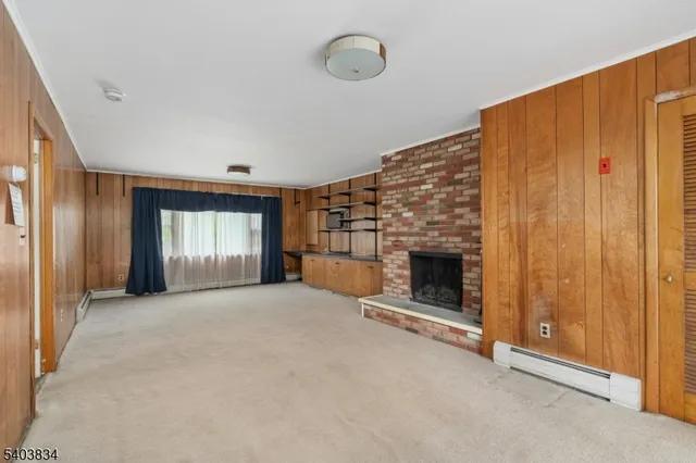 an empty room with windows and fireplace