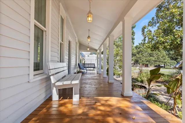 a view of a patio with table and chairs with wooden floor and fence