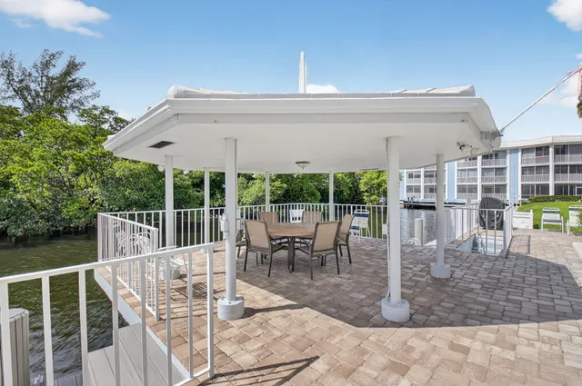 a view of a patio with a dining table and chairs with wooden floor