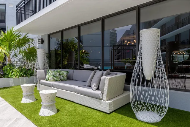 a view of swimming pool with a couches chairs and a yard
