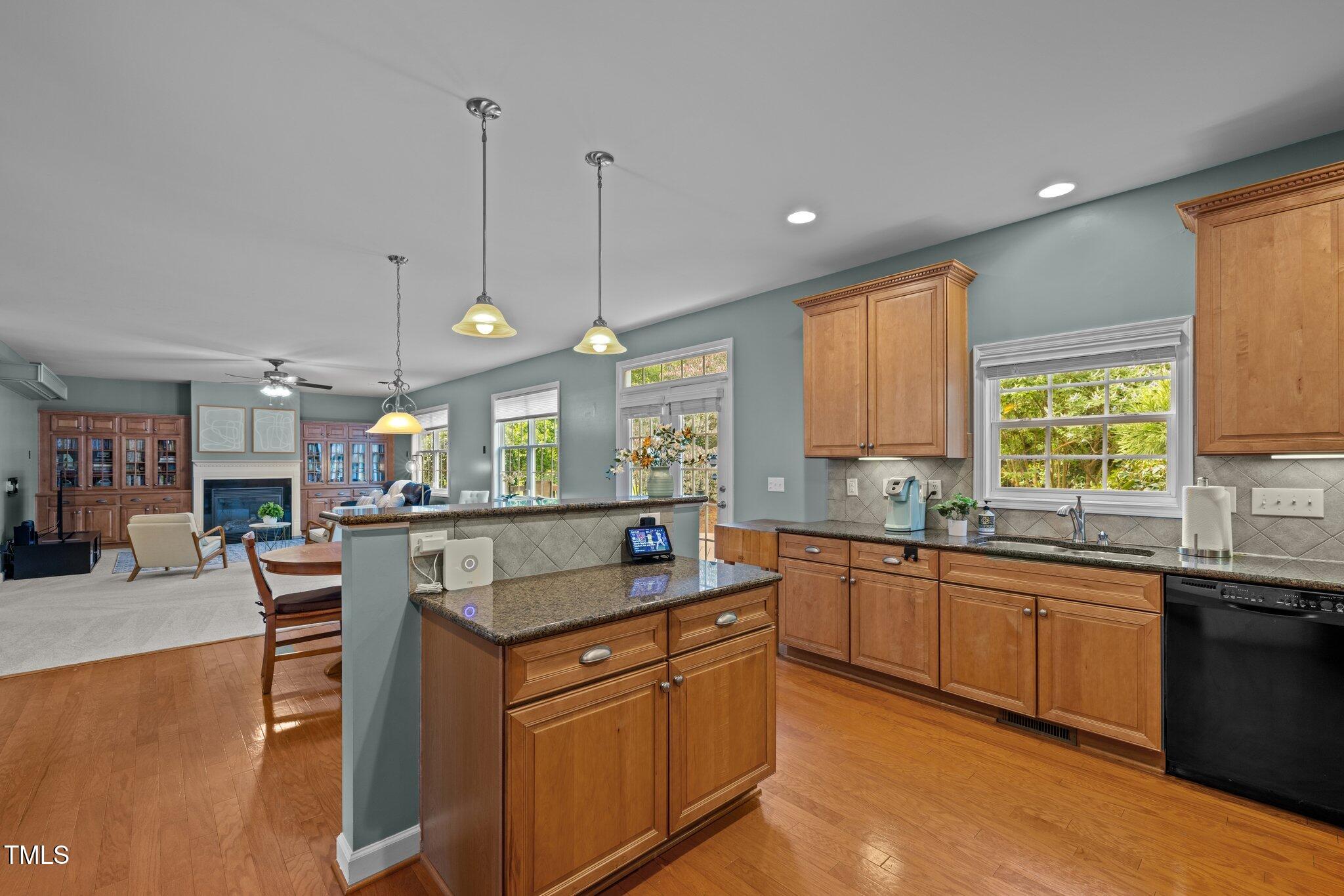 705 Harkness Circle Durham, NC 27705 - Photo 10 of 58 a large kitchen with stainless steel appliances granite countertop a sink a stove and a wooden floors