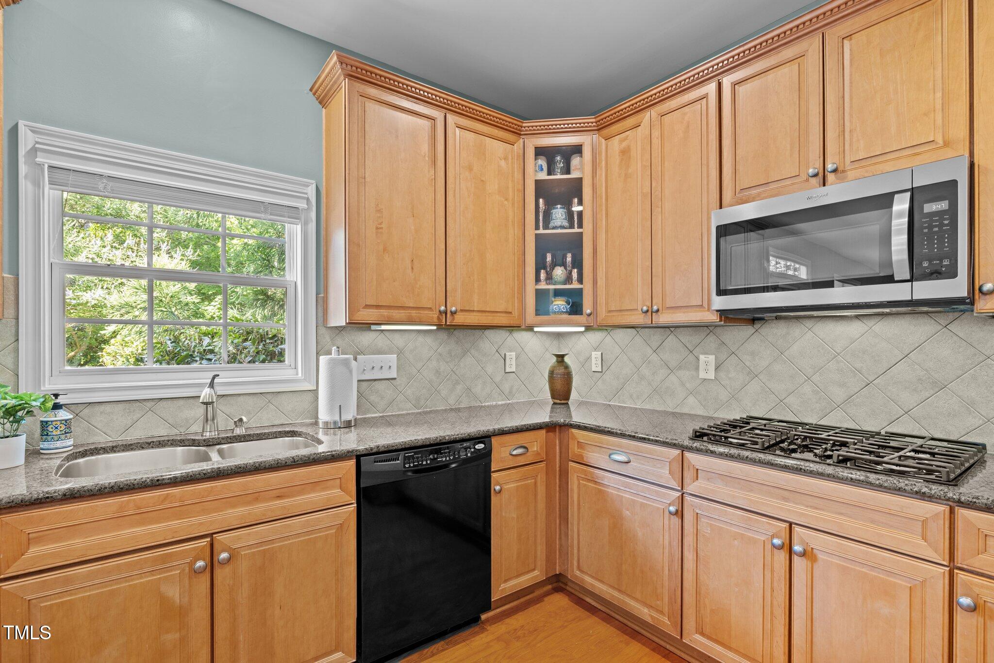 705 Harkness Circle Durham, NC 27705 - Photo 11 of 58 a kitchen with stainless steel appliances granite countertop white cabinets a sink and a stove next to a window