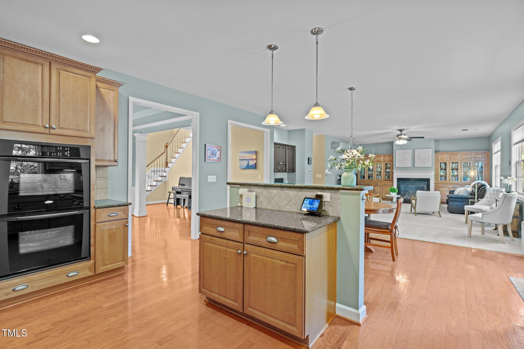 705 Harkness Circle Durham, NC 27705 - Photo 12 of 58 a kitchen with stainless steel appliances granite countertop a stove a sink a oven a dining table and chairs with wooden floor