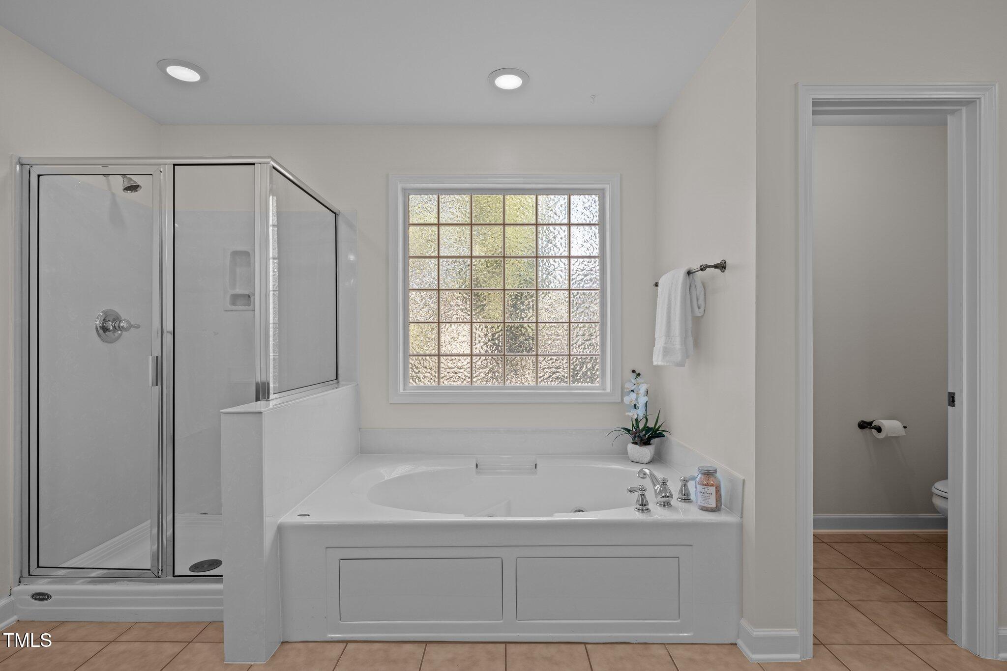 705 Harkness Circle Durham, NC 27705 - Photo 19 of 58 a bathroom with a bathtub and a shower