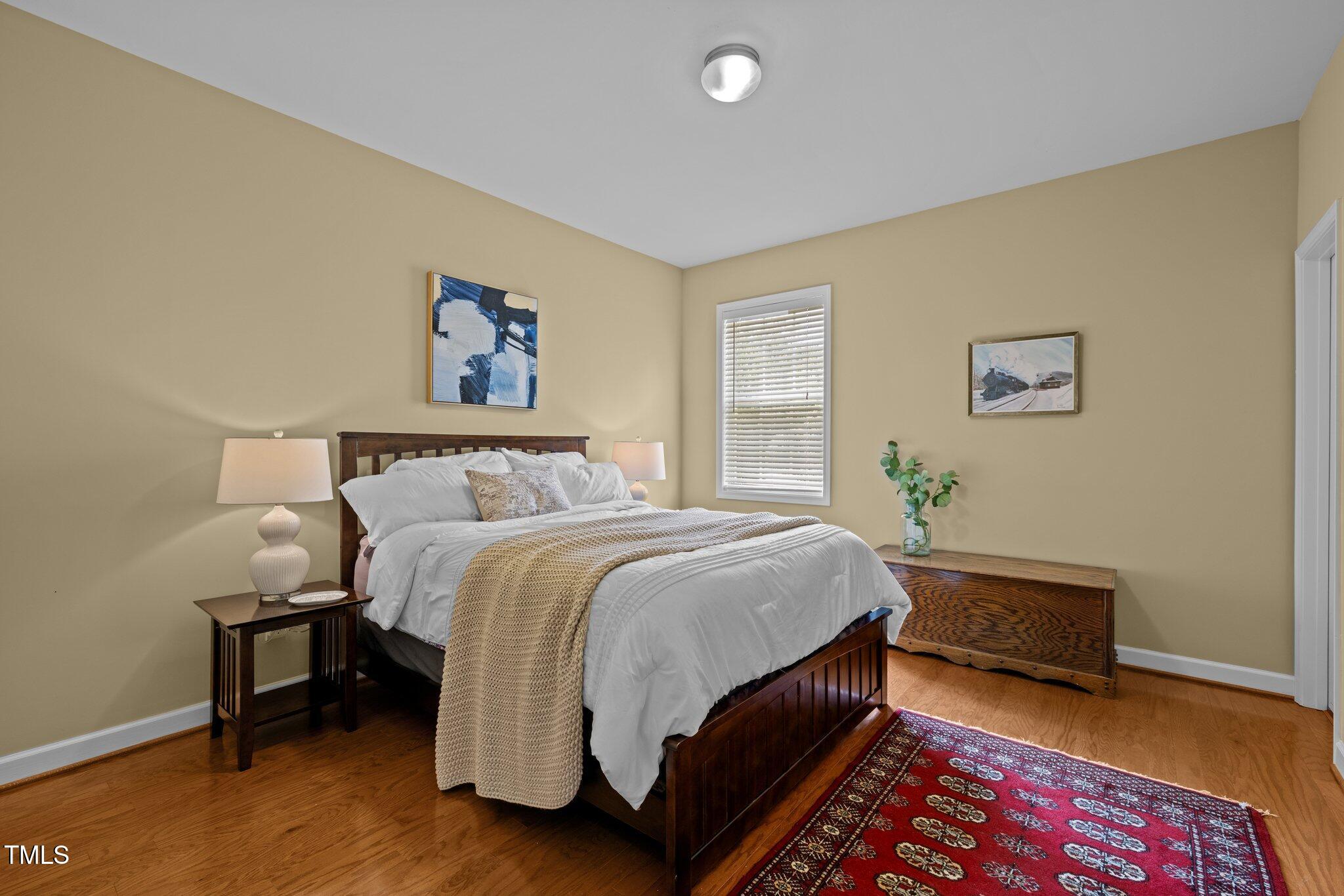 705 Harkness Circle Durham, NC 27705 - Photo 30 of 58 a bedroom with a bed and a lamp on dresser