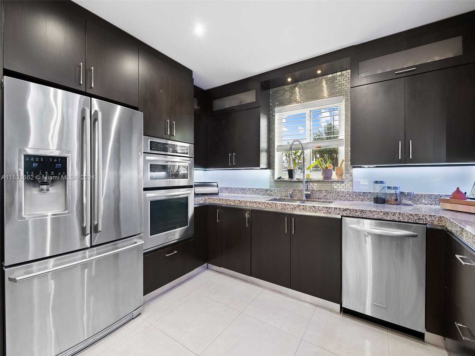 3444 Pierce Street Hollywood, FL 33021 - Photo 13 of 27 a kitchen with granite countertop a sink stainless steel appliances and cabinets
