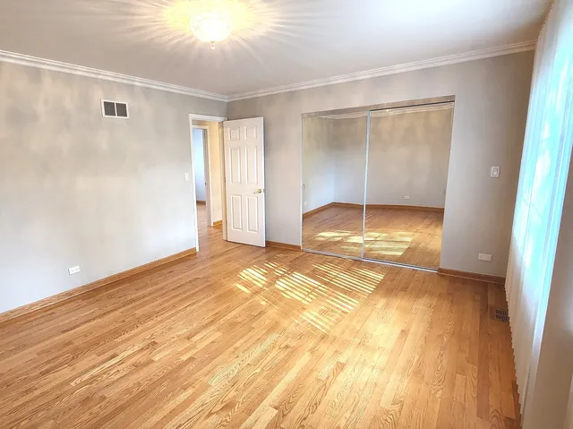 a view of empty room with wooden floor