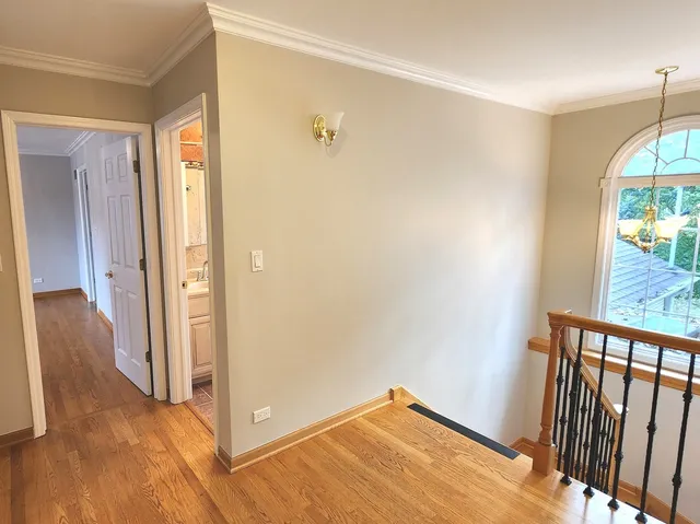 a view of a hallway with wooden floor and glass door