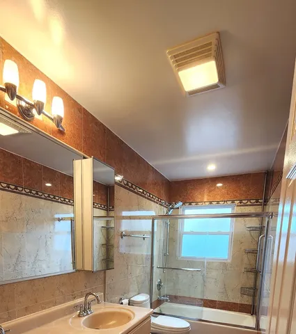a bathroom with a sink mirror and shower