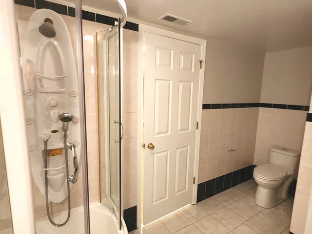 a bathroom with a granite countertop sink and a washer dryer