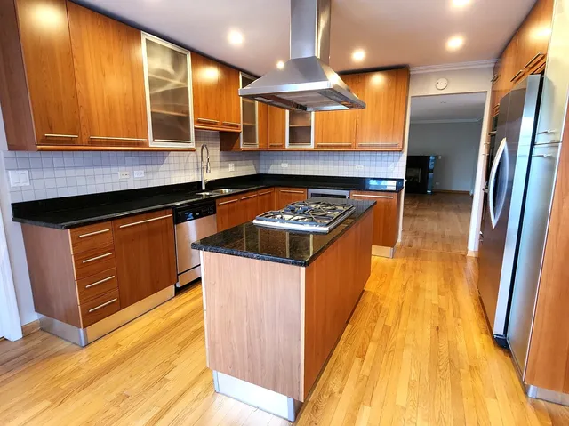 a kitchen with stainless steel appliances granite countertop a stove a sink and a refrigerator
