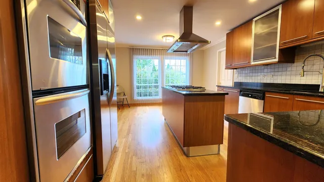 a kitchen with stainless steel appliances granite countertop a refrigerator a sink and a stove