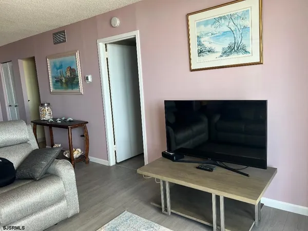 a bedroom with two bed and a painting on the wall