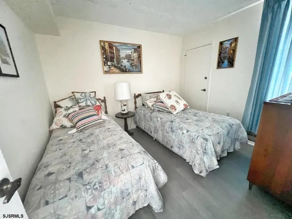 a bedroom with two beds and a painting on the wall
