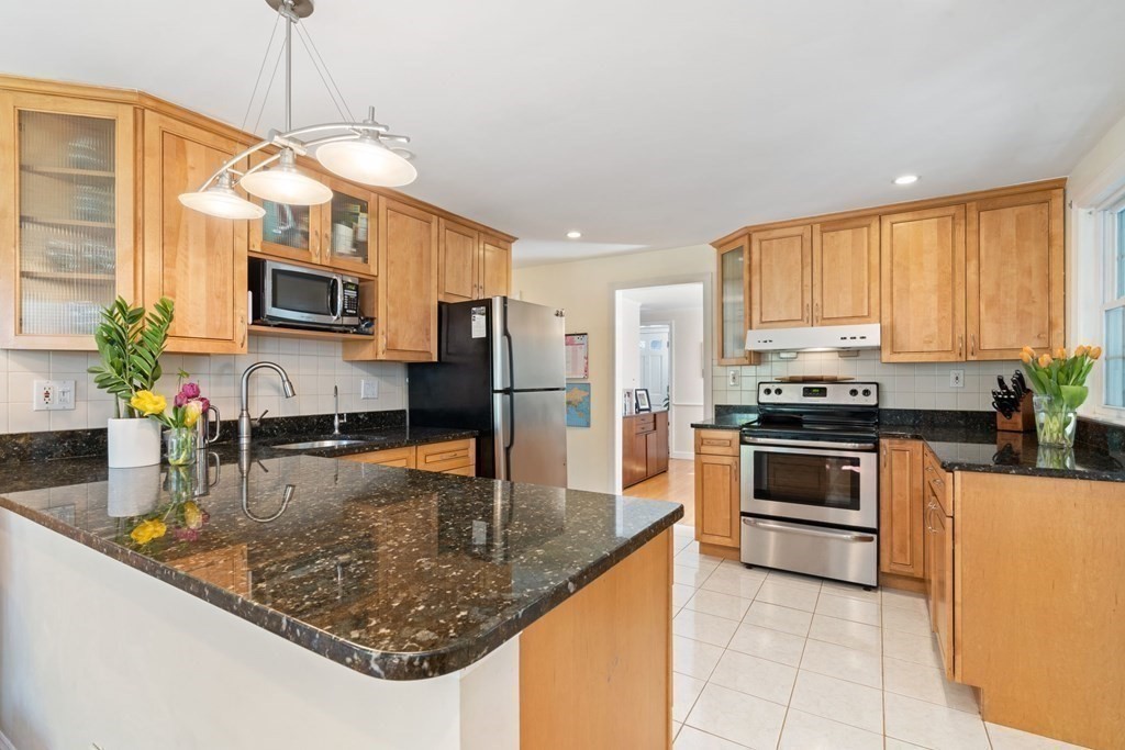 265 Riverside Drive Dedham, MA 02026 - Photo 10 of 41 a kitchen with stainless steel appliances granite countertop a sink a stove top oven a counter space and cabinets