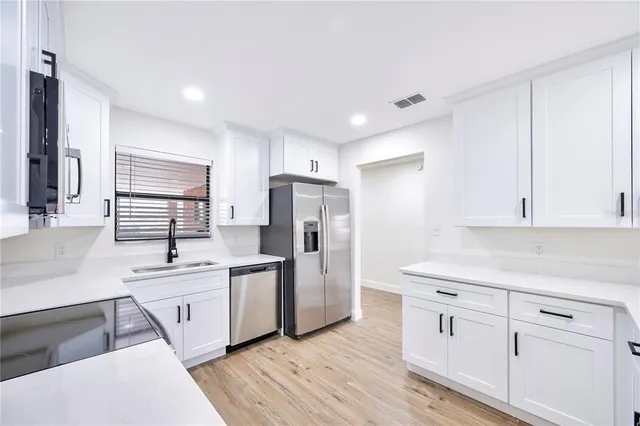 a kitchen with white cabinets and white appliances