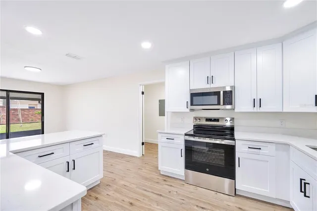 a kitchen with stainless steel appliances white cabinets and a stove