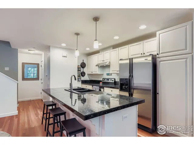 a kitchen with stainless steel appliances granite countertop a sink refrigerator and cabinets