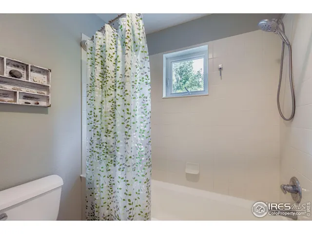 a bathroom with a shower curtain and a shower
