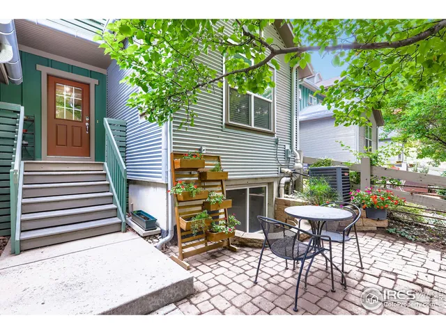 a view of a chair and table in backyard of the house