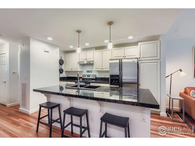a kitchen with stainless steel appliances granite countertop a sink refrigerator and cabinets
