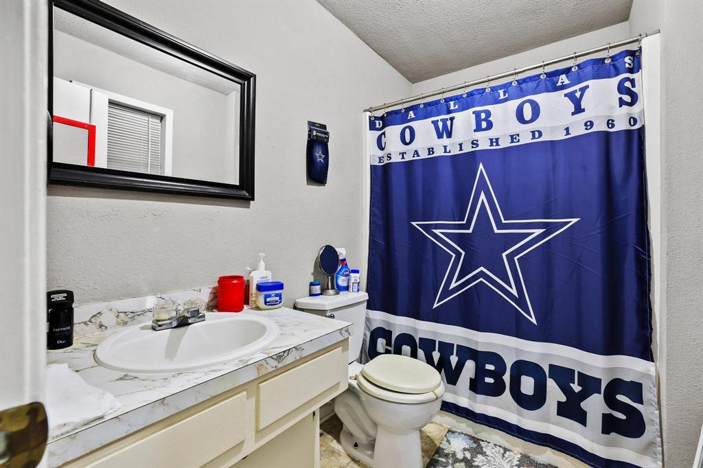 606 Hunter Street Bonham, TX 75418 - Photo 11 of 15 a bathroom with a sink and a mirror