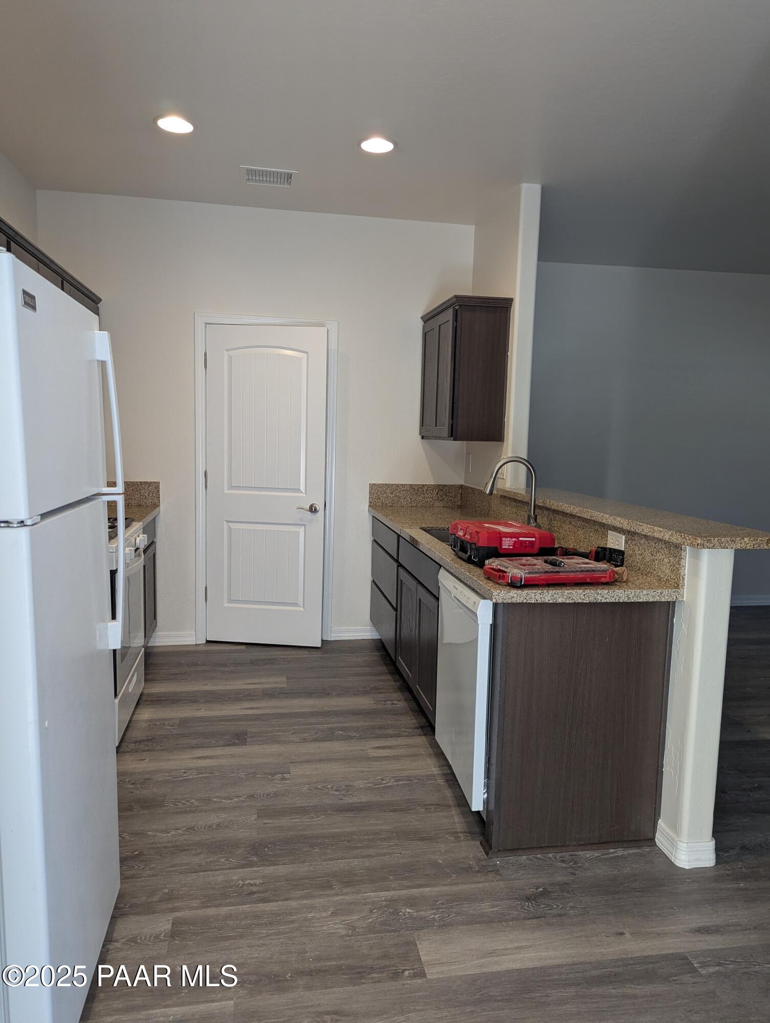 2976 North Yavapai Road East, Unit 2 Prescott Valley, AZ 86314 - Photo 3 of 12 a kitchen with stainless steel appliances granite countertop a stove and a refrigerator