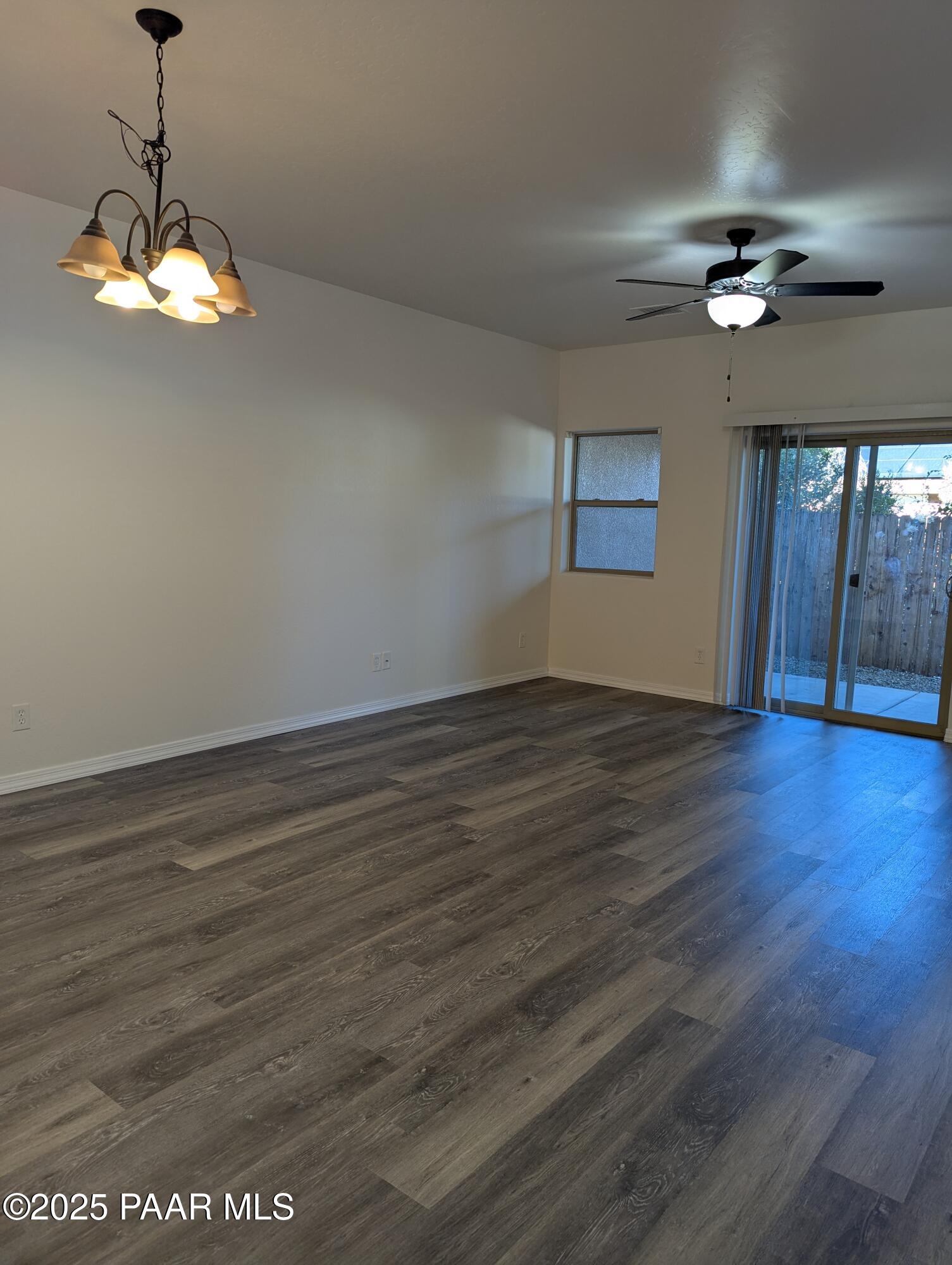 2976 North Yavapai Road East, Unit 2 Prescott Valley, AZ 86314 - Photo 5 of 12 a view of an empty room with wooden floor and a chandelier