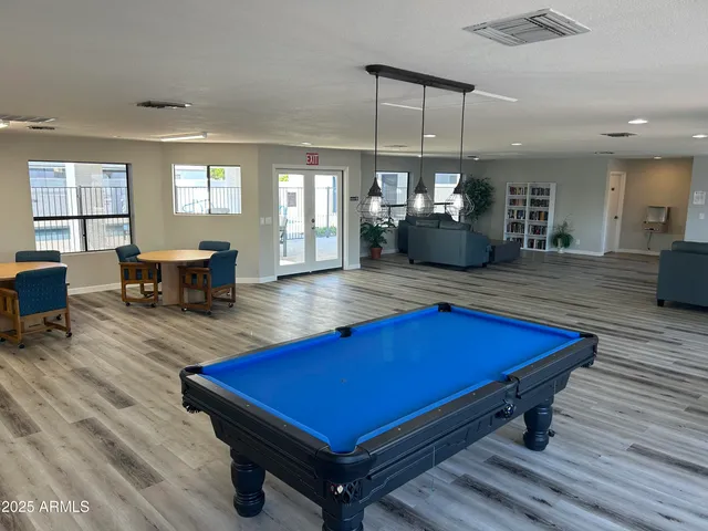 a room with pool table and windows