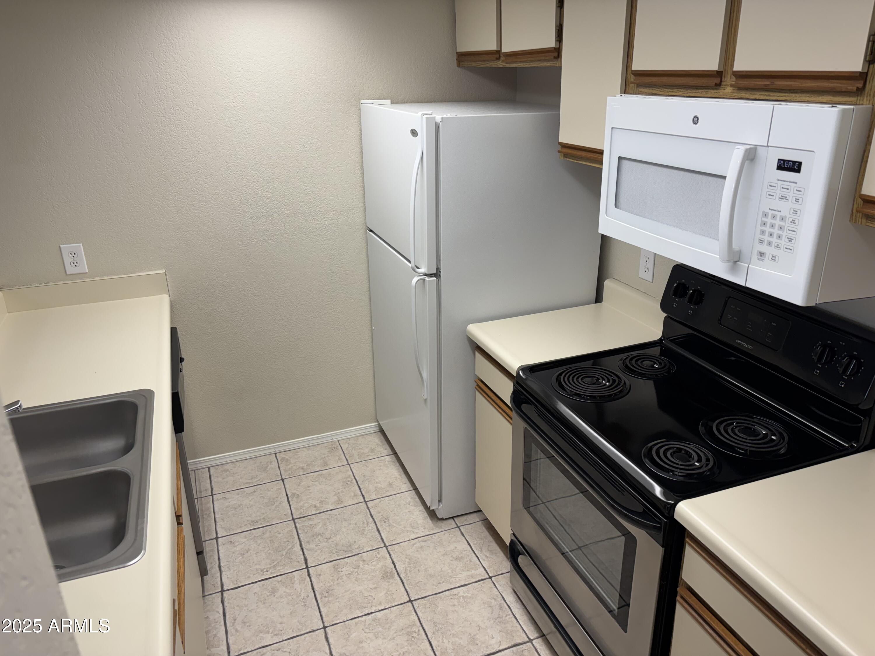 1444 North Recker Road, Unit 163 Mesa, AZ 85205 - Photo 4 of 19 a kitchen with a stove and a refrigerator