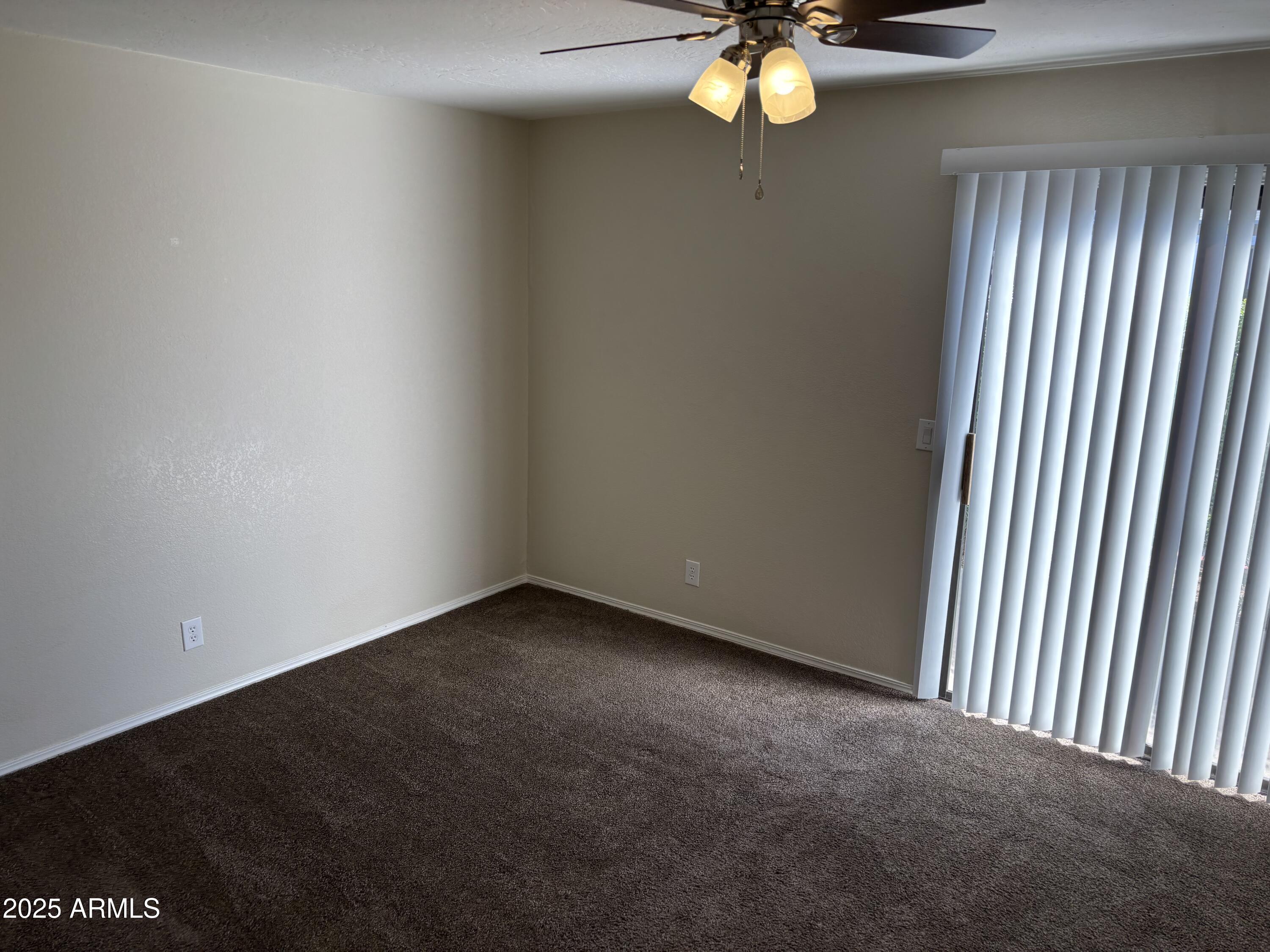 1444 North Recker Road, Unit 163 Mesa, AZ 85205 - Photo 6 of 19 a view of an empty room with window and wooden floor