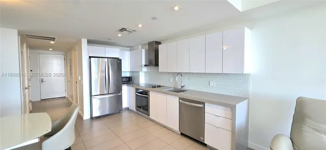 a living room with furniture and view of kitchen