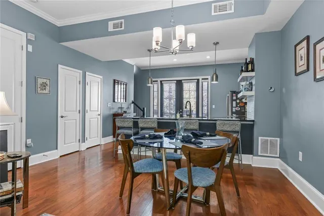 a dining room with stainless steel appliances granite countertop furniture wooden floor and a kitchen view