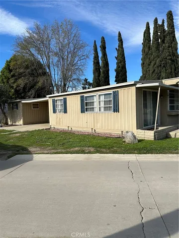 a view of a house with backyard and bushes