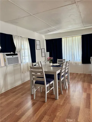a dining room with furniture window and wooden floor