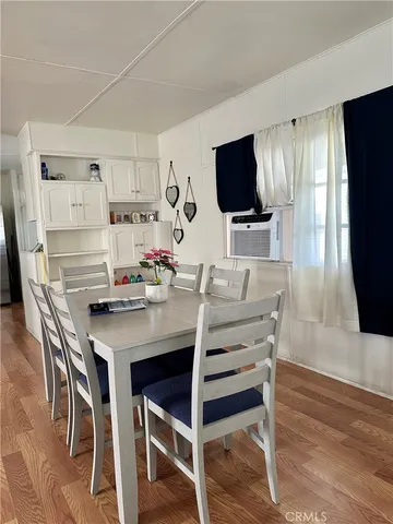 a view of a dining room with furniture wooden floor and a flat screen tv