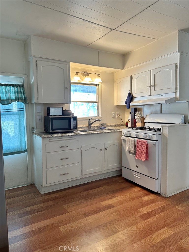 5800 Hamner Avenue, Unit 53 Eastvale, CA 91752 - Photo 9 of 19 a kitchen with stainless steel appliances granite countertop a sink a stove and cabinets