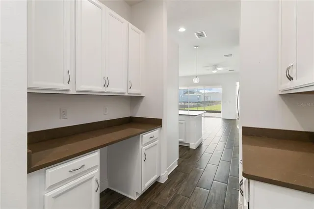 a kitchen with granite countertop white cabinets and a sink