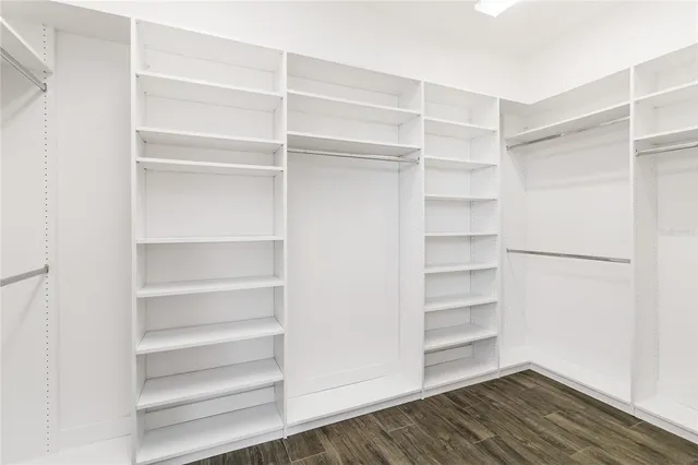a view of walk in closet with empty racks