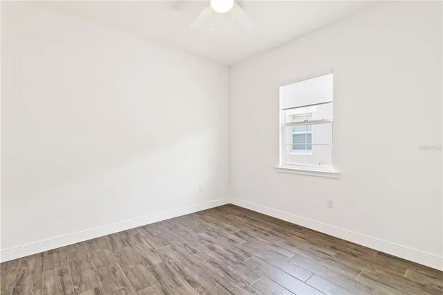a view of a room with wooden floor and a window