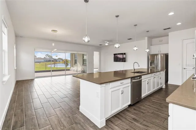 a large kitchen with stainless steel appliances kitchen island granite countertop a large counter top and wooden floors