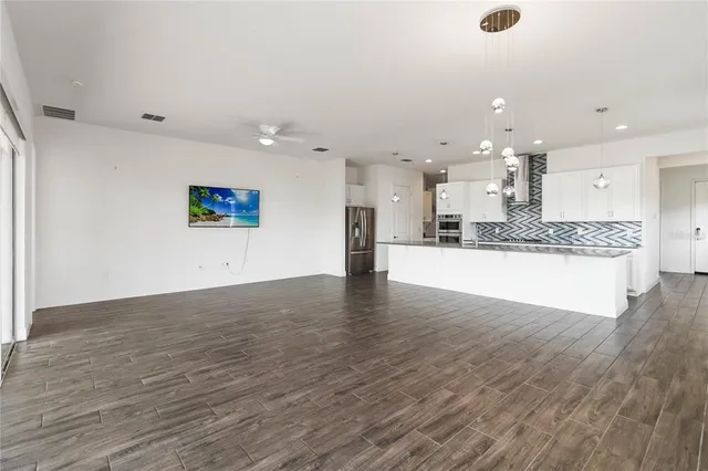 a view of kitchen and kitchen with granite countertop wooden floor