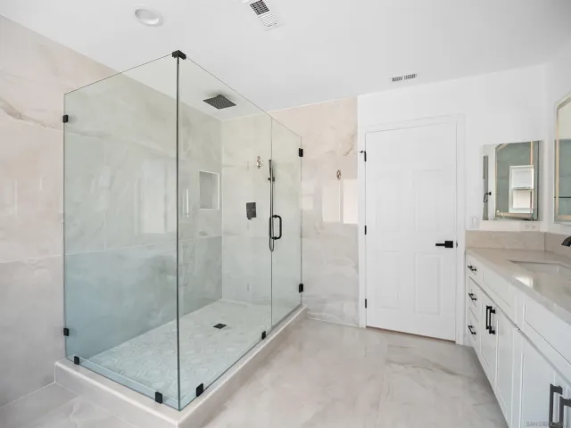 a bathroom with a shower sink and mirror