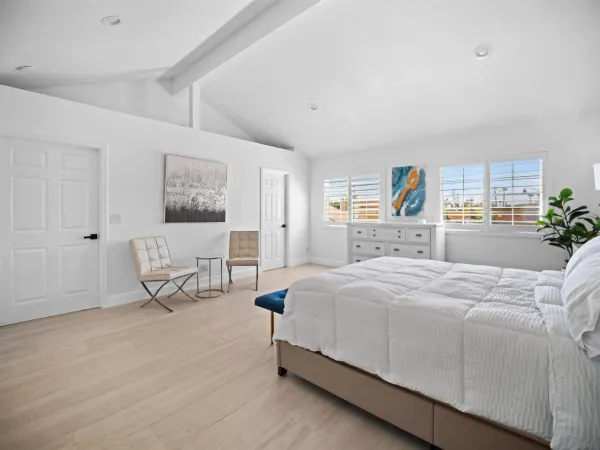 a spacious bedroom with a bed and a cabinets