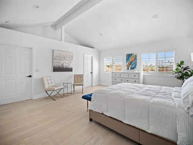 a spacious bedroom with a bed and a cabinets