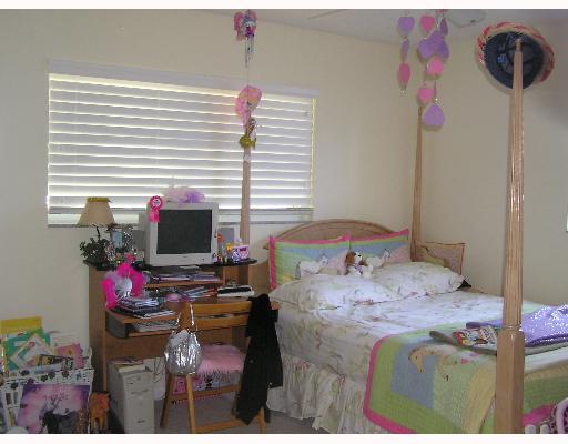 3573 Northwest 4th Avenue Boca Raton, FL 33431 - Photo 14 of 16 a bedroom with a bed dresser and a flat screen tv