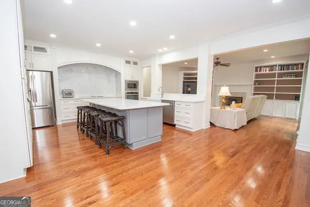 a kitchen with stainless steel appliances kitchen island hardwood floor sink and stove