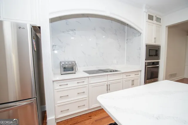 a large kitchen with kitchen island a sink a stove and a refrigerator