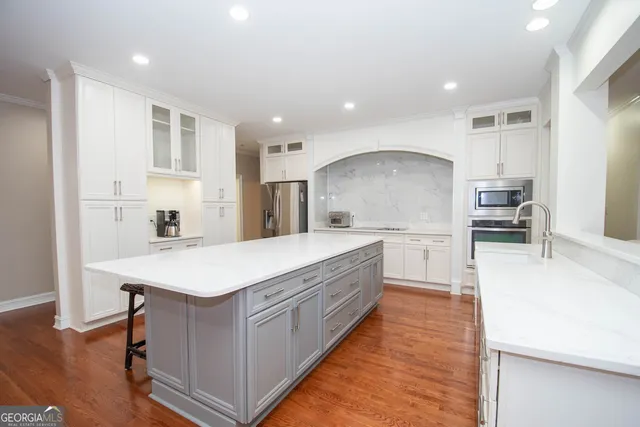 a kitchen with white cabinets and stainless steel appliances